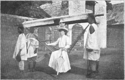 Mrs. Davis in a Borrowed "Hammock," the Local Means
of Transport on the West Coast.