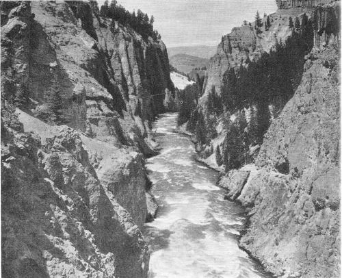 Downstream from the main part of the canyon, the Yellowstone River winds in a narrow ribbon through the gray and buff walls of a rocky gorge. With the changing light, the river varies from silver to jade green.